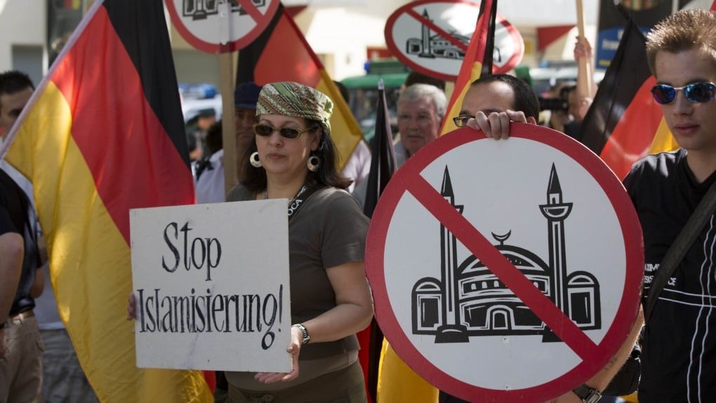 Demonstrators display signs with crossed-out mosques during a protest in front of a mosque in Berlin, Germany, Saturday. (photo credit: AP)