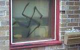 An illustrative photo of a spray-painted swastika on a window (ADL/JTA)