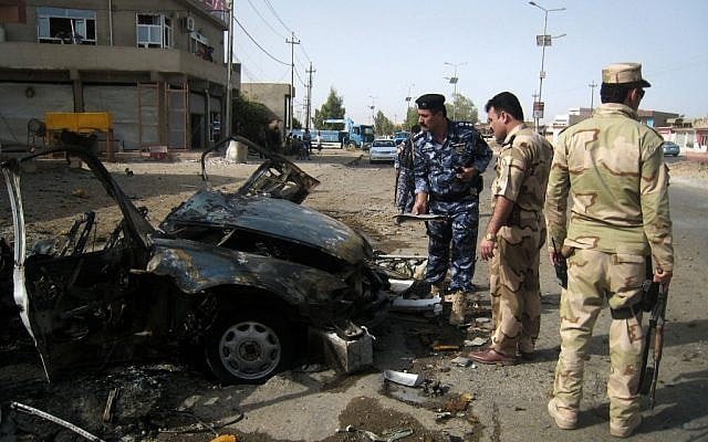 Security forces inspect the scene of a car bomb attack in Kirkuk, 290 kilometers (180 miles) north of Baghdad, Iraq, Thursday, Aug 16, 2012. Five separate bombings in central and northern Iraq, killed and wounded scores of people early Thursday, police said. (Emad Matti/AP)