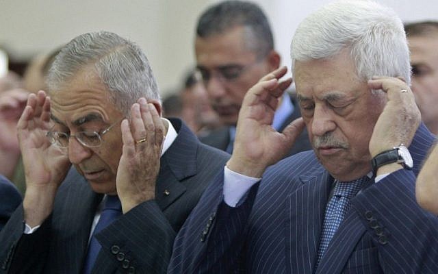 Palestinian President Mahmoud Abbas, right, and Prime Minister Salam Fayyad, left, attend prayers in Ramallah. (photo credit: AP)