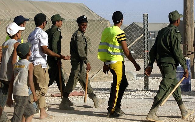 Jordanian security guards enter the Zaatari Refugee camp with their batons in Mafraq, Jordan, in August (photo credit: Mohammad Hannon/AP)