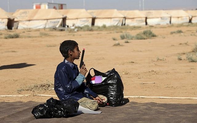 A Syrian refugee plays with a toy gun at Zaatari Refugee Camp in Mafraq, Jordan, Sunday, Aug. 19 (photo credit: AP/Mohammad Hannon)