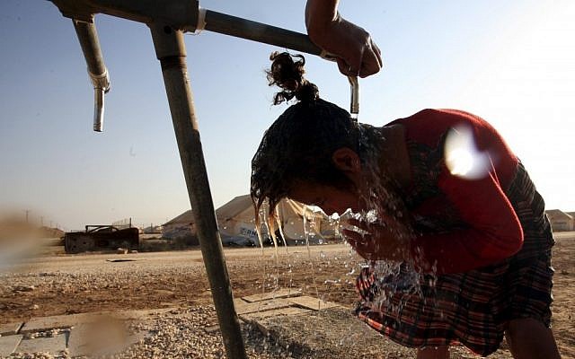 A Syrian girl washes up in the Zaatari Refugee camp, in Mafraq, Jordan (photo credit: AP/Mohammad Hannon)