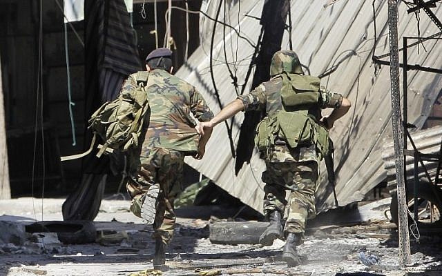 Lebanese army soldiers run from a sniper at an outdoor market in Tripoli in August. (photo credit: AP) Lebanese army soldiers run from a sniper at an outdoor market in Tripoli in August. (photo credit: AP)