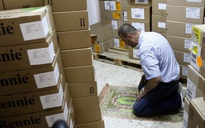 An employee of a Palestinian drug import company prays at the company's warehouse in the West Bank city of Ramallah. The cash crunch, mainly due to a sharp drop in foreign aid since 2011, is threatening to set off a chain reaction of business failures, layoffs and economic downturn that would undermine one of the West's fundamental strategies toward resolving the Israeli-Palestinian conflict. (AP Photo/Nasser Shiyoukhi)