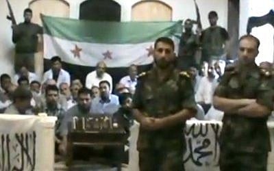 An image made from a video released by the Baraa Brigades and accessed Sunday, Aug. 5, 2012, purports to show Free Syrian Army soldiers guarding a group of Iranians abducted a day earlier and promising more attacks on Iranian targets in Damascus, Syria. (photo credit: Baraa Brigades via AP video)