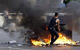 A Lebanese Shiite Muslim blocks the street in a southern suburb of Beirut, Lebanon, to protest against Syrian rebels' kidnapping of 12 Lebanese Shiite pilgrims in the Syrian northern province of Aleppo on Tuesday, May 22, 2012. (photo credit: Bilal Hussein/AP)