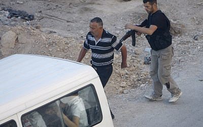 A Syrian rebel detains a man at an improvised checkpoint in a suburb of Damascus August 2 (photo credit: AP)