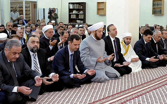 Syrian president Bashar Assad performs Eid prayers in the Hamad Mosque in Damascus, Syria, Sunday, Aug. 19, 2012. (photo credit: SANA / AP)
