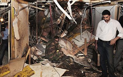 In this photo a Syrian security force inspects the scene after a bomb ripped through the third floor of the state TV building in Damascus, Syria, on Monday (photo credit: AP Photo/SANA)