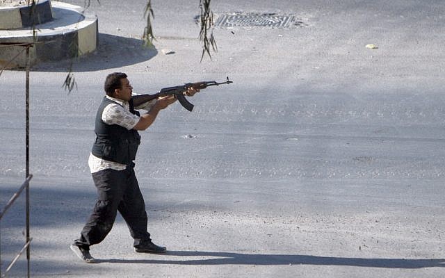 A Syrian rebel fighter fires at an approaching car at an improvised checkpoint in a suburb of Damascus, August 2 (photo credit: AP) A Syrian rebel fighter fires at an approaching car at an improvised checkpoint in a suburb of Damascus, August 2 (photo credit: AP)
