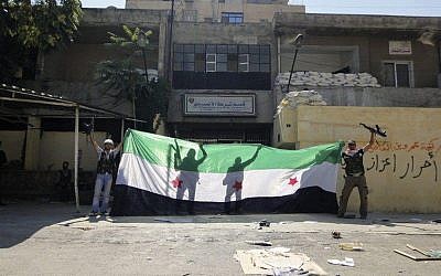 Syrian rebels celebrating after taking over the Ansari police station in the northern city of Aleppo, Syria, on August 3 (photo credit: AP)