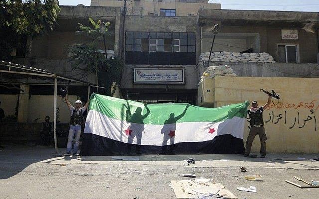 Syrian rebels celebrating after taking over the Ansari police station in the northern city of Aleppo, Syria, on August 3 (photo credit: AP)