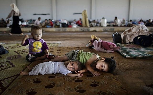 Syrian children, who fled their home with their family, lie on the ground, while they and others take refuge at the Bab Al-Salameh border crossing, in hopes of entering one of the refugee camps in Turkey, near the Syrian town of Azaz, Sunday, Aug. 26, 2012. (photo credit: Muhammed Muheisen/AP) Syrian children, who fled their home with their family, lie on the ground, while they and others take refuge at the Bab Al-Salameh border crossing, in hopes of entering one of the refugee camps in Turkey, near the Syrian town of Azaz, Sunday, Aug. 26, 2012. (photo credit: Muhammed Muheisen/AP)