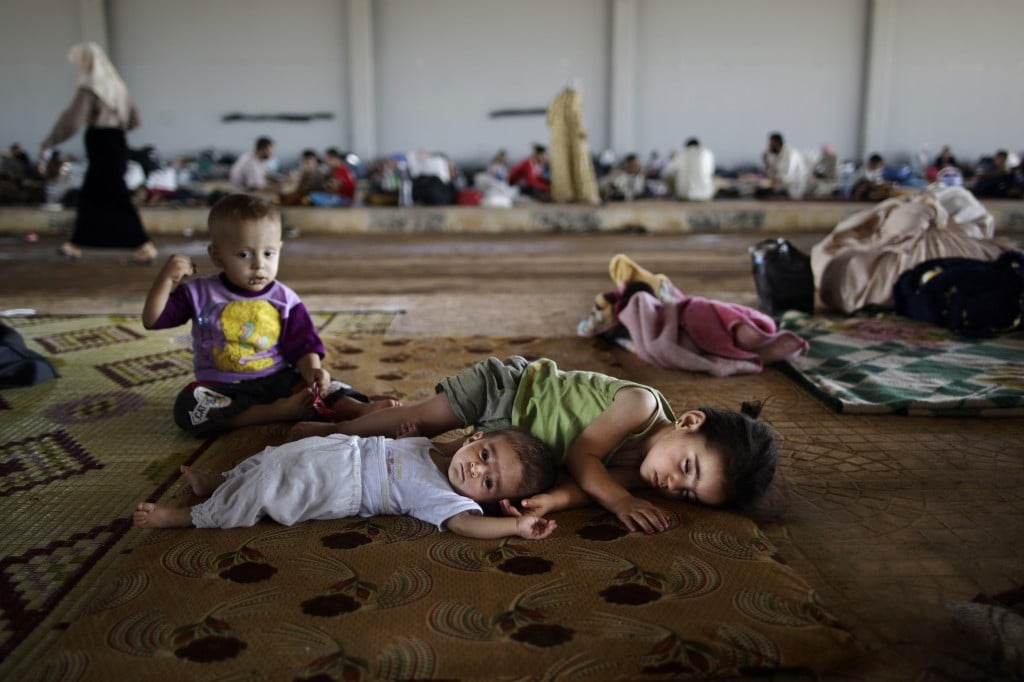 Syrian children, who fled their home with their family, lie on the ground, while they and others take refuge at the Bab Al-Salameh border crossing, in hopes of entering one of the refugee camps in Turkey, near the Syrian town of Azaz, Sunday, Aug. 26, 2012. (photo credit: Muhammed Muheisen/AP) Syrian children, who fled their home with their family, lie on the ground, while they and others take refuge at the Bab Al-Salameh border crossing, in hopes of entering one of the refugee camps in Turkey, near the Syrian town of Azaz, Sunday, Aug. 26, 2012. (photo credit: Muhammed Muheisen/AP)
