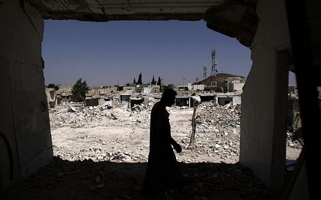 A Syrian man walks in his house, which was destroyed in a Syrian government forces shelling, over looking the rubble of other houses, in Azaz, on the outskirts of Aleppo, Syria, Wednesday, Aug. 29, 2012. (photo credit: Muhammed Muheisen/AP)