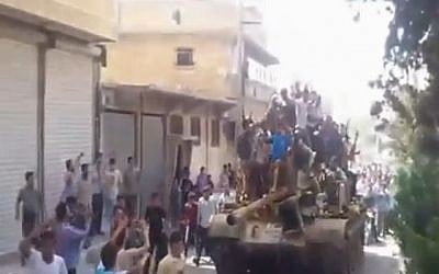 Free Syrian Army troops riding through Al Bab on a captured Syrian army tank. (photo credit: Image capture from YouTube)