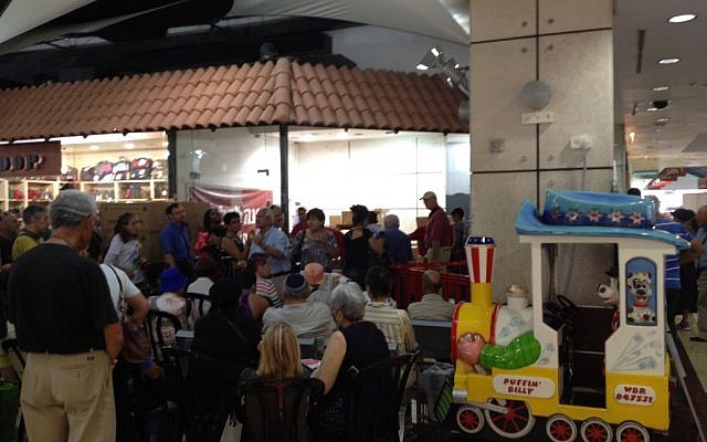 Israelis crowd a gas mask distribution point at a shopping mall Thursday (photo credit: Times of Israel/Matti Friedman)