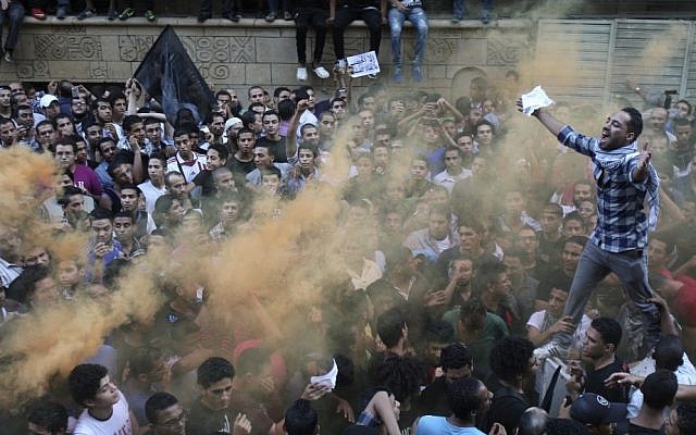 Protesters chant slogans amid orange smoke outside the US embassy in Cairo last week (photo credit: Mohammed Abu Zaid/AP)