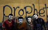 Egyptian protesters wearing Guy Fawkes masks pose for a photo in front of graffiti on a wall of the US Embassy during a protest in Cairo, Egypt, Tuesday, September 11, 2012 (photo credit: Nasser Nasser/AP)