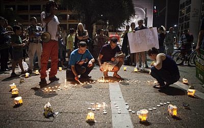 Israelis light candles in the shape of a clock during a protest against the government decision to return to winter clock more than a month ahead of Europe and the US in Tel Aviv, Saturday, September 22, 2012 (photo credit: AP/Dan Balilty)