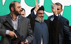 Hezbollah leader Hassan Nasrallah, center, escorted by his bodyguards, waves to a crowd of hundreds of thousands of supporters in Beirut, Lebanon in September, 2012. (Illustrative photo credit: AP/Hussein Malla)
