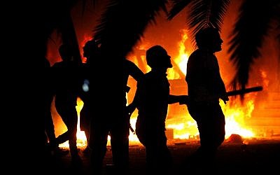 Libyan civilians watch fires in Ansar al-Shariah Brigades compound, after hundreds raided the Brigades base, in Benghazi, Libya, Friday, Sept. 21 (photo credit: AP/Mohammad Hannon) Libyan civilians watch fires in Ansar al-Shariah Brigades compound, after hundreds raided the Brigades base, in Benghazi, Libya, Friday, Sept. 21 (photo credit: AP/Mohammad Hannon)