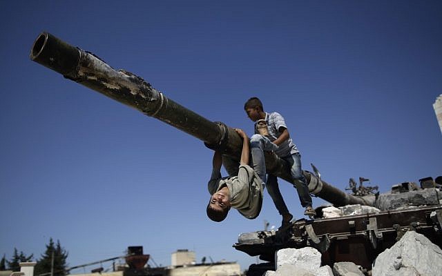 Children play on a Syrian tank destroyed during fighting in the Syrian town of Azaz, on the outskirts of Aleppo, September 2, 2012 (photo credit: AP/Muhammed Muheisen) Children play on a Syrian tank destroyed during fighting in the Syrian town of Azaz, on the outskirts of Aleppo, September 2, 2012 (photo credit: AP/Muhammed Muheisen)