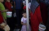 A Syrian girl who fled her home due to fighting between the Syrian army and the rebels waits her turn to buy bread and eggs near a border crossing with Turkey, on Monday, September 3 (photo credit: AP/Muhammed Muheisen)