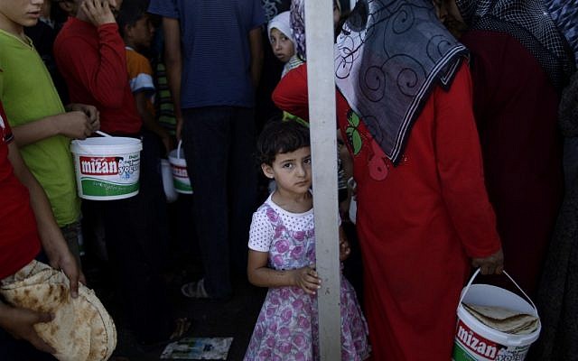 A Syrian girl who fled her home due to fighting between the Syrian army and the rebels waits her turn to buy bread and eggs near a border crossing with Turkey, on Monday, September 3 (photo credit: AP/Muhammed Muheisen)