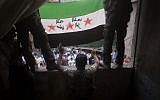 Members of the Free Syrian Army hold up a revolutionary flag in Aleppo, September 21 (photo credit: AP Photo/ Manu Brabo)