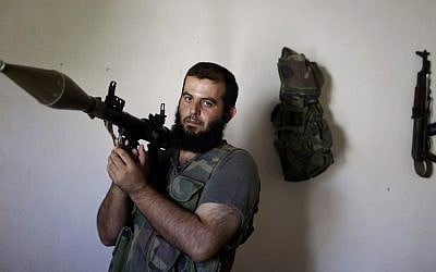 In this Tuesday, Sept. 4, 2012, photo, Syrian rebel fighter, Abu Muslim, 30, a former librarian, poses for a picture at a house where he and others wait their turn to go and fight against government forces in Aleppo, in Marea on the outskirts of Aleppo.(AP Photo/Muhammed Muheisen)