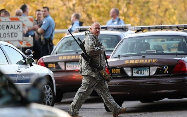 An officer walks through the area as police investigate a shooting at Accent Signage Systems on the north side of Minneapolis on Thursday (photo credit: AP/The Star Tribune/Renee Jones Schneider)
