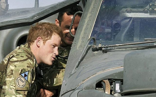 Great Britain's Prince Harry examines the cockpit of an Apache attack helicopter at Camp Bastion in Afghanistan in early September. (photo credit: AP/John Stillwell)