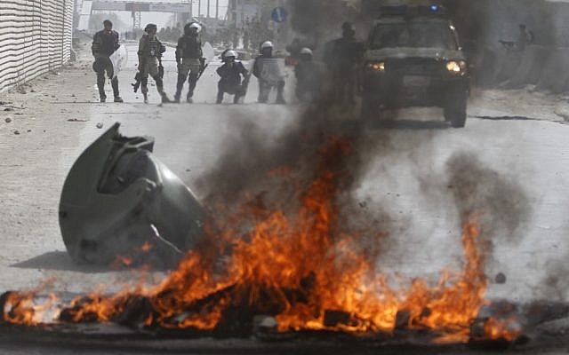 Afghan police stand by burning tires Monday in Kabul during violent protests against the anti-Islam film that ridicules the Muslim Prophet Muhammad. (photo credit: AP Photo/Ahmad Jamshid) Afghan police stand by burning tires Monday in Kabul during violent protests against the anti-Islam film that ridicules the Muslim Prophet Muhammad. (photo credit: AP Photo/Ahmad Jamshid)