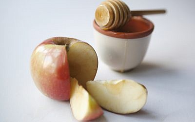 Illustrative photo of an apple dipped in honey - symbols of Rosh Hashanah, the Jewish New Year (Michal Fattal/Flash90)