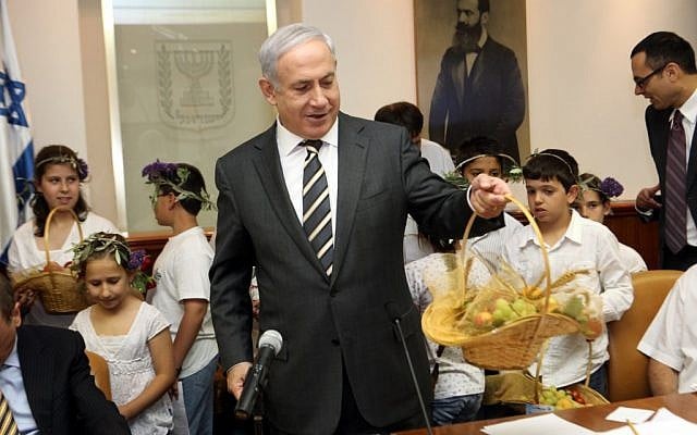 Netanyahu with a fruit basket during the holiday of Shavuot.  This season has seen a spike in Israelis requesting help from food organizations (photo credit: Yossi Zamir/Flash90)