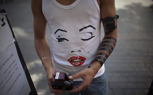 A young Israeli man stops to put on tefillin in downtown Jerusalem. (Photo credit: Yonatan Sindel/Flash90)