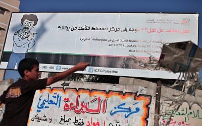 A Palestinian next to an elections billboard in Gaza. (photo credit: Wissam Nassar/Flash90)