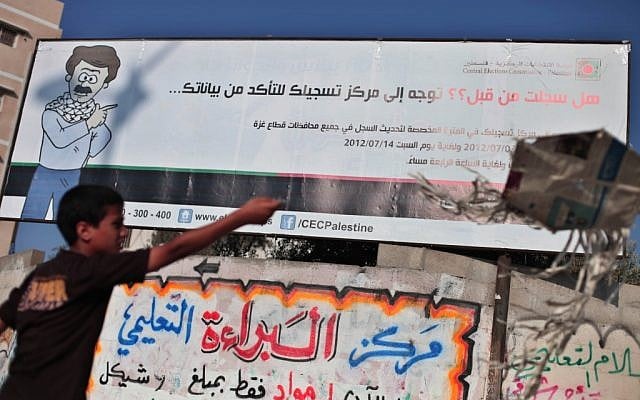 A Palestinian next to an elections billboard in Gaza. (photo credit: Wissam Nassar/Flash90)