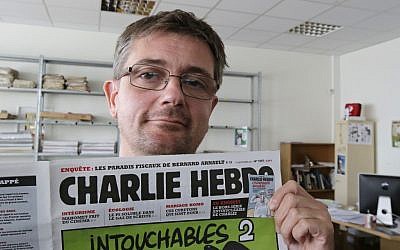 Publishing director of the satyric weekly Charlie Hebdo, Charb, displays the front page of the newspaper as he poses for photographers in Paris, Wednesday, Sept. 19, 2012. (photo credit: AP/MIchel Euler)