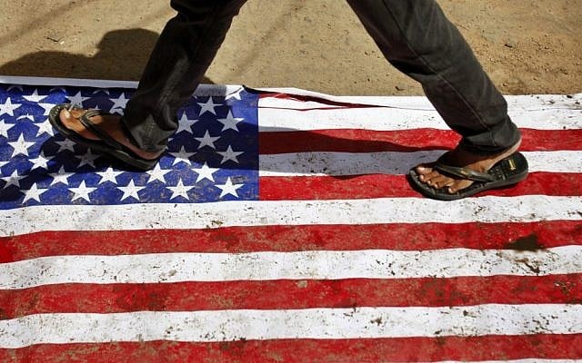 An Indian man walks on an American flag in Hyderabad, India, during a day of protests in more than 20 countries against an anti-Islam movie on Friday (photo credit: AP/Mahesh Kumar A.) An Indian man walks on an American flag in Hyderabad, India, during a day of protests in more than 20 countries against an anti-Islam movie on Friday (photo credit: AP/Mahesh Kumar A.)