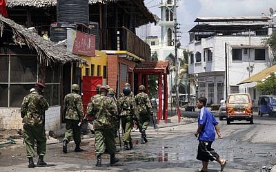 Kenyan Paramilitary soldiers patrol after clearing the area of Muslim youths who were shouting slogans of 'Allah Akbar', God is Great, after the Friday prayers outside the Musa Mosque in the Majengo suburb of Mombasa Kenya, Friday. (photo credit: AP)