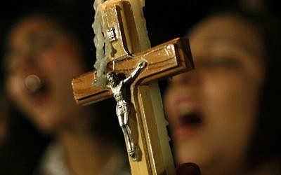 In this Sunday, Oct. 16, 2011 file photo, Egyptian Copts carry a cross and a candle and chant prayers while taking part in a protest marking one week since deadly clashes between Coptic protesters and the military, in Cairo. (photo credit: AP/Nasser Nasser)