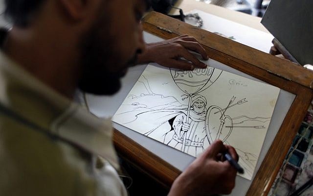 Egyptian cartoonist Khalid Abdul-Ati from the Egyptian Al Watan daily newspaper works on a cartoon depicting an Islamic figure inside his office at the newspaper's headquarters in Cairo on Wednesday. (photo credit: AP/Nasser Nasser)