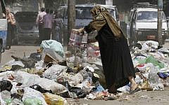 Illustrative photo of a woman in Cairo throwing her garbage into the street. (AP)