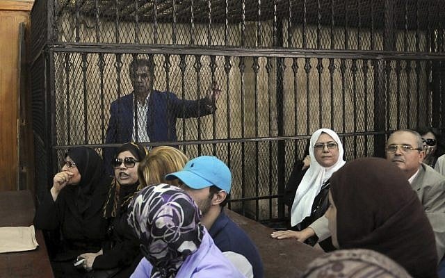 Tawfiq Okasha, a popular Egyptian TV presenter accused of inciting the killing of the country's new president on air, stands in the defendants cage at the opening of his trial, in Cairo, Egypt, on Saturday, Sept. 1 (photo credit: AP/Mohammed Assad) Tawfiq Okasha, a popular Egyptian TV presenter accused of inciting the killing of the country's new president on air, stands in the defendants cage at the opening of his trial, in Cairo, Egypt, on Saturday, Sept. 1 (photo credit: AP/Mohammed Assad)