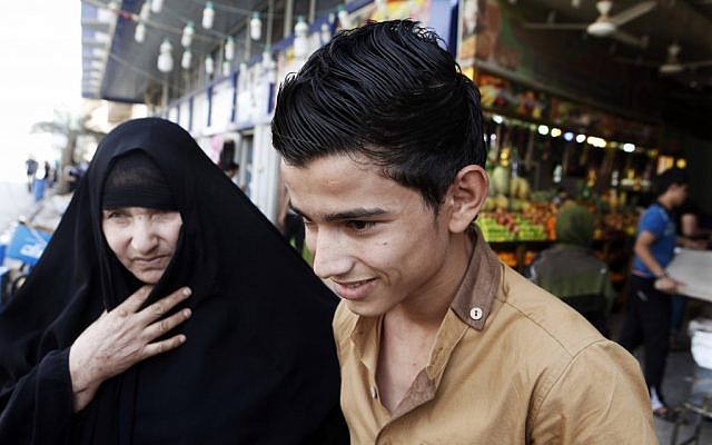 A mother with her young son shop at a market place in Kazimiyah neighborhood, northern Baghdad, Iraq, Sunday, Sept 2 (photo credit: AP/Karim Kadim)