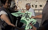 A Japanese group of survivors of the atomic bomb on Hiroshima during World War 2 hold signs calling for the abolition of Nuclear weapons at the Western Wall on September 10, 2012. (photo credit: Sebastian Scheiner/AP)