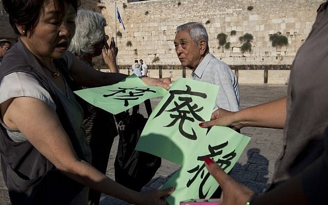 A Japanese group of survivors of the atomic bomb on Hiroshima during World War 2 hold signs calling for the abolition of Nuclear weapons at the Western Wall on September 10, 2012. (photo credit: Sebastian Scheiner/AP)